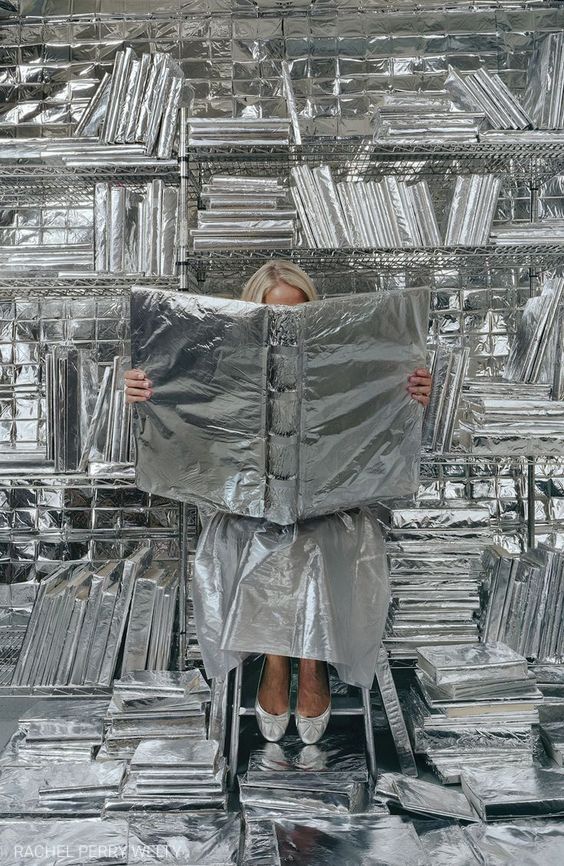 Woman sits in aluminum foil background