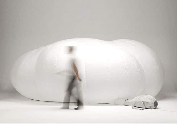 Model walks blearily across an inflatable cloud