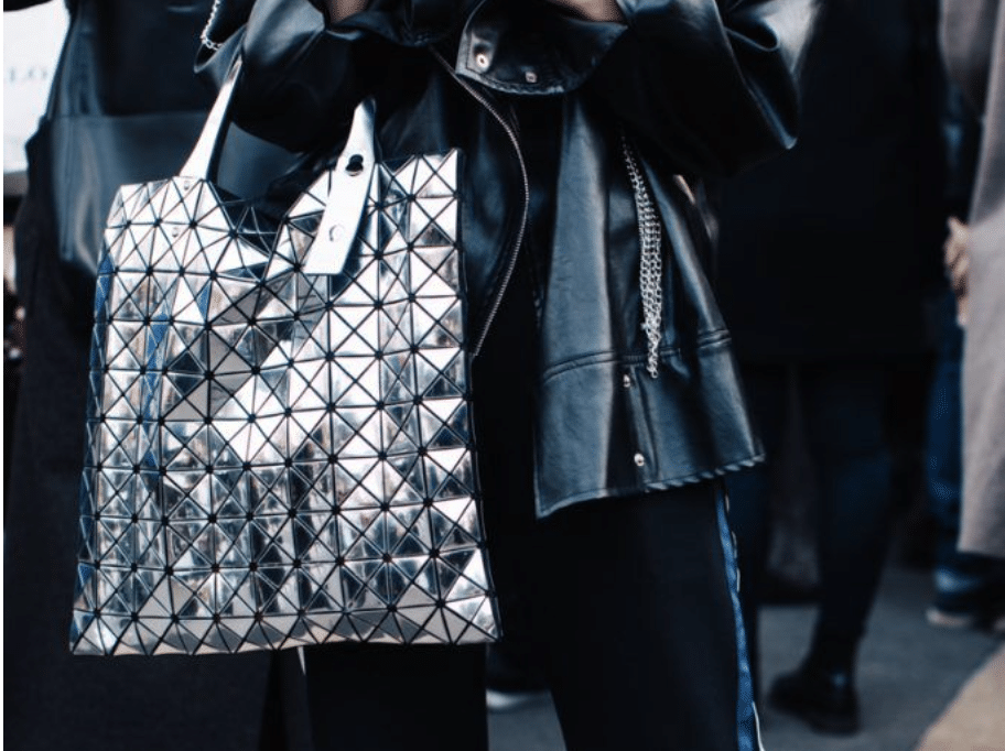 Streetstyler carries metallic shopping bag at Milan Fashion Week